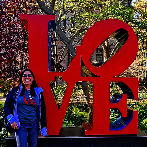 Lisa Niver posing beside Penn love sign